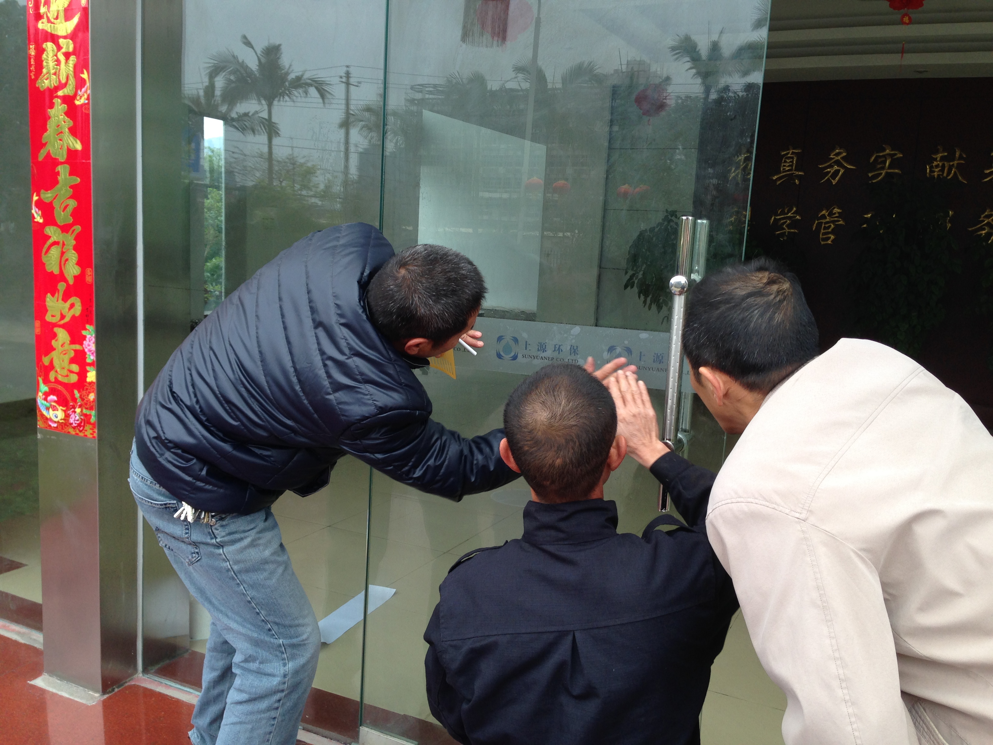 小心翼翼地給玻璃門貼標(biāo)簽.JPG